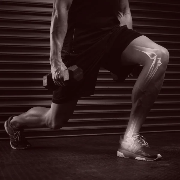 Un homme effectue un squat avec un haltère dans le cadre d'un entraînement physique.